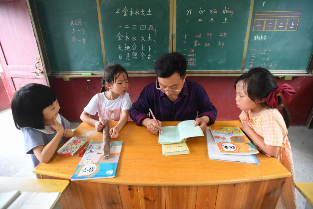 在湖南省株洲市茶陵县的虎踞镇茶干小学，乡村教师董朱文（右二）在批改语文作业（2020年9月8日摄）。新华社记者 陈泽国 摄